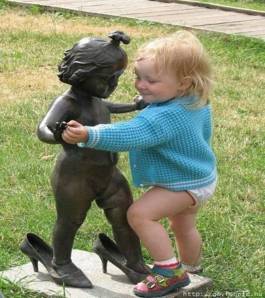 Picture of toddler dancing with a statue.